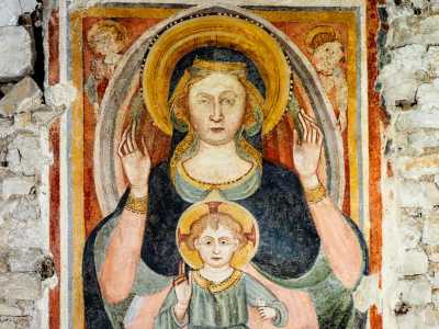 L�affresco, datato al secondo quarto del XV secolo, mostra al centro una Vergine orante vestita con un manto blu e rosa che tiene sulle gambe Ges� Bambino